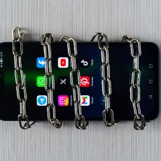 Teléfono móvil con redes sociales en la pantalla encadenado